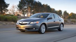 A silver 2013 Acura ILX driving on a highway