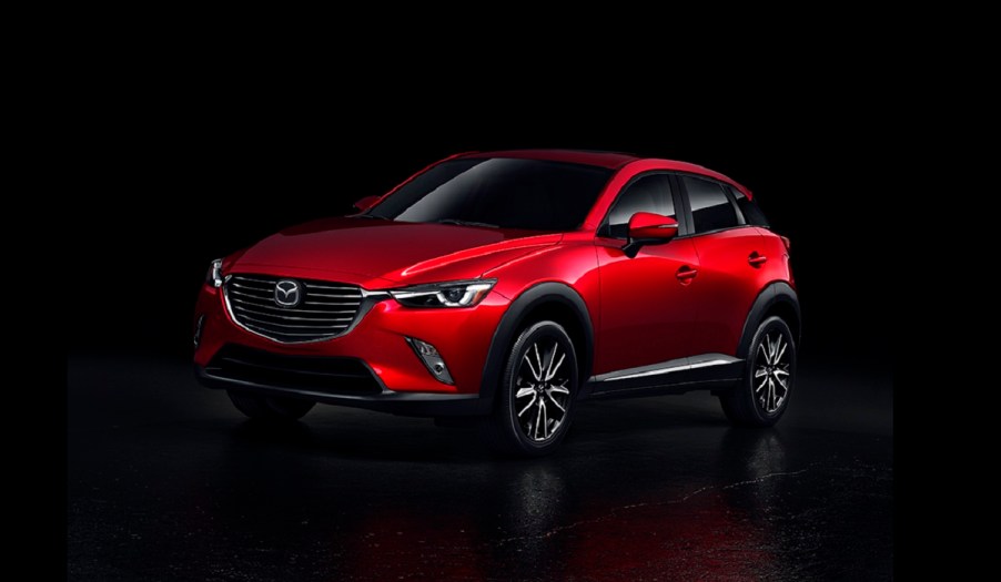 A red 2016 Mazda CX-3 against a black background.