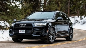 A black 2019 Audi Q7 driving down a snowy road.