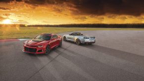 A pair of Chevy Camaros at sunset