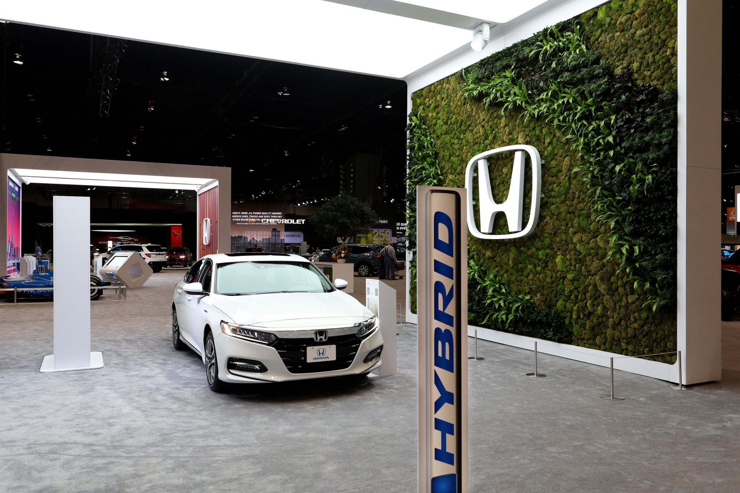 A white 2021 Honda Accord, one of the best midsized sedans on sale today, shot in an auto show booth from the front 3/4 angle