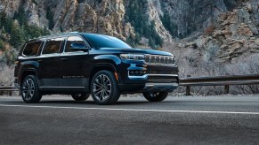 A black 2022 Jeep Grand Wagoneer driving by the mountains.