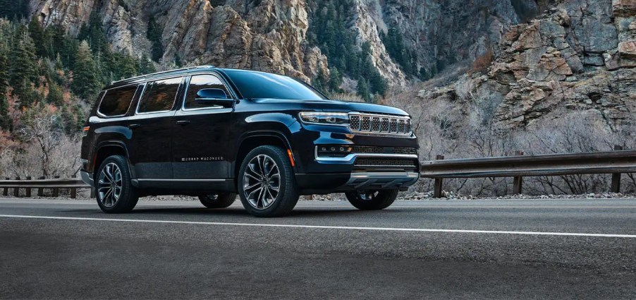 A black 2022 Jeep Grand Wagoneer driving by the mountains.