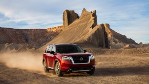 A red 2022 nissan pathfinder driving through a desert