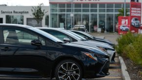 A line of 2022 Toyota Corolla models, shot in profile on a Toyota dealership lot