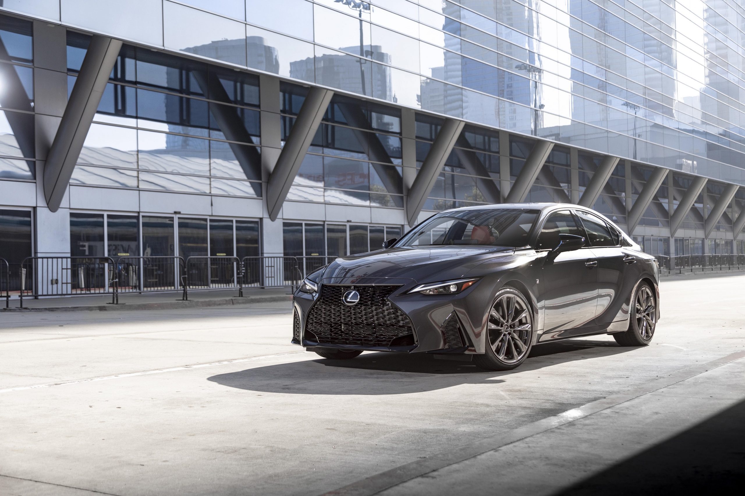 A grey 2022 Lexus IS sedan shot from the front 3/4 on an empty city street