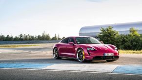 Porsche's hot pink Taycan parked in a lot.