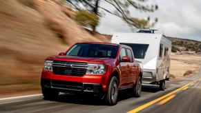 A red 2022 Ford Maverick towing a camper