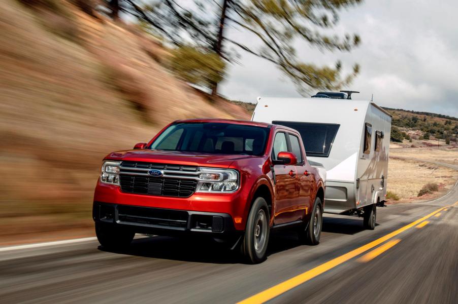 A red 2022 Ford Maverick towing a camper