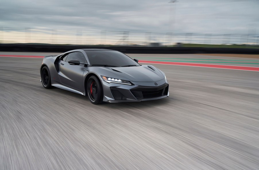 Acura NSX Type S on a race track photographed at speed turning towards the view of the camera. It has a large angular front air dam and red brake calipers.