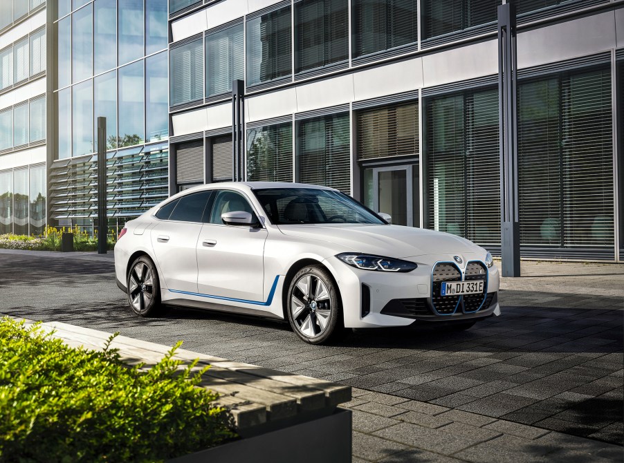 The BMW i4 electric sedan in white with blue accents along the lower sides of the car and around the front grilles.