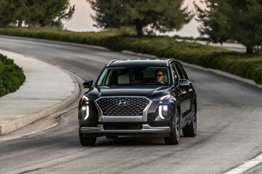 Black 2022 Hyundai Palisade driving on a curvy road