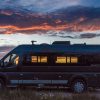 Camper Van Parked In Front Of Sunset