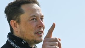 Creator of Tesla, Elon Musk dressed in black with a black handkerchief around his neck.