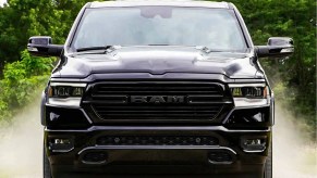 A black 2021 Ram 1500 driving down a dirt road.