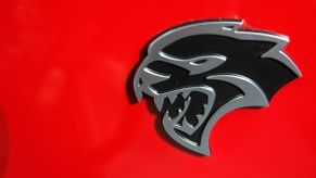 A Dodge Challenger Hellcat logo on a red car.