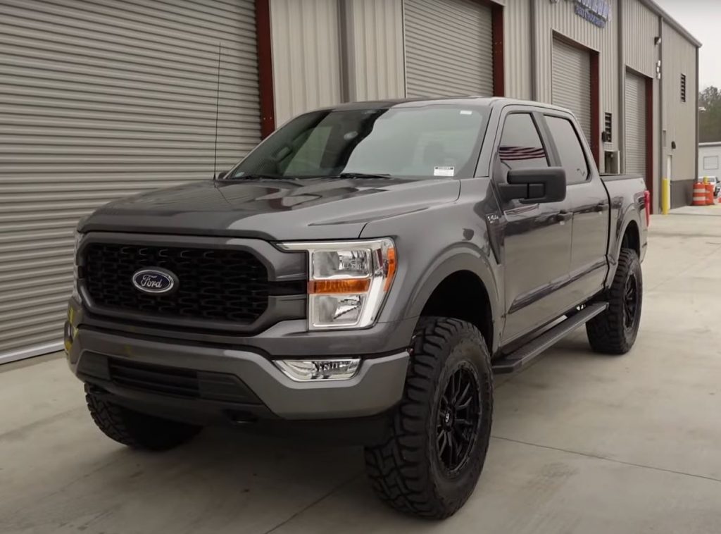 A grey F-150 SuperCrew with a 6-inch lift parked outside