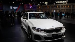 An Alpine White 2021 BMW M340i under the showroom lights shot from the high front 3/4 angle