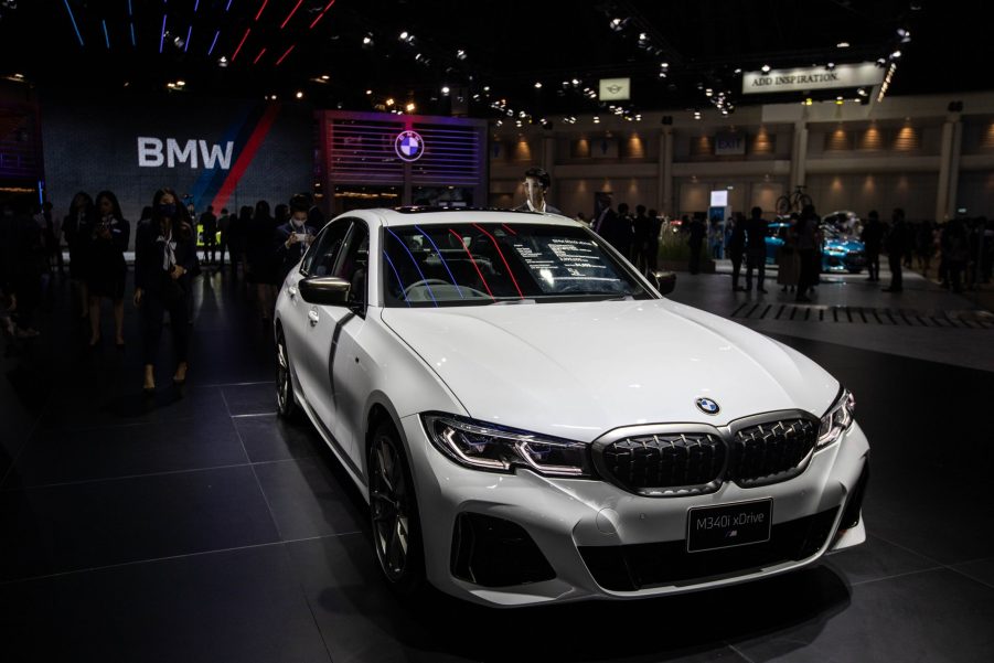 An Alpine White 2021 BMW M340i under the showroom lights shot from the high front 3/4 angle