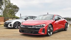 A red and silver Audi RS e-tron GT photographed as a pair from the front 3/4 angle