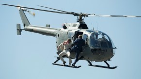 This is a picture of stuntmen as they perform a battle hanging from a helicopter during the filming of the James Bond movie 'Spectre' at Zocalo Main Square in Mexico City, Mexico. The Spectre fight is one of many memorable James Bond helicopter scenes. | Miguel Tovar/LatinContent/Getty Images