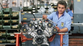 An engineer works on a Ferrari engine at the factory in Maranello, Italy. (Photo by �� Vittoriano Rastelli/CORBIS/Corbis via Getty Images). EU combustion ban may affect the engines in future Ferrari, Lamborghini and Porsche supercars.