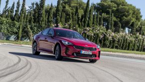 The Kia Stinger luxury car on a race track, shot from the low front 3/4 angle