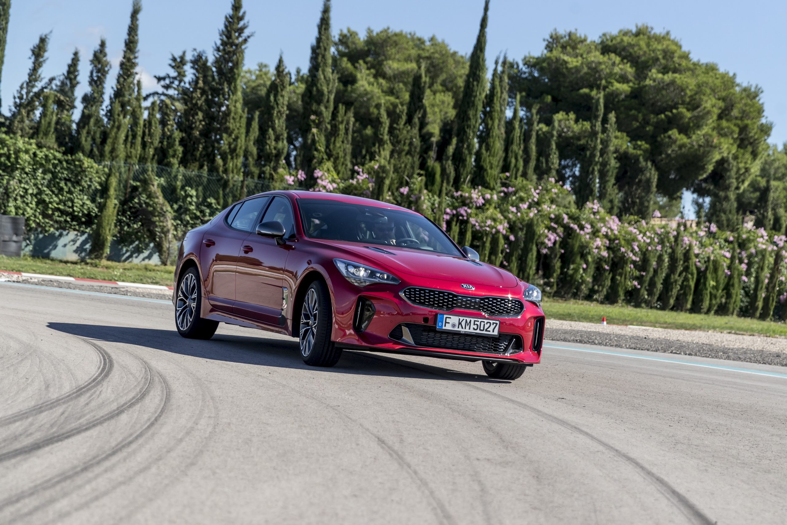 The Kia Stinger luxury car on a race track, shot from the low front 3/4 angle