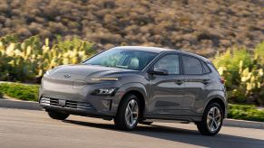 Gray 2022 Hyundai Kona Electric driving by some cacti