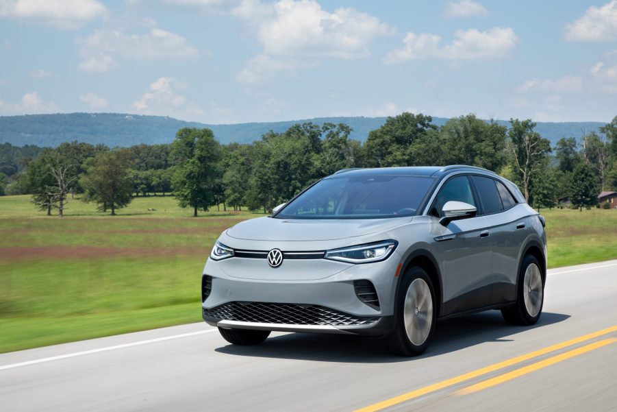 Gray Volkswagen ID.4 driving by a grassy field