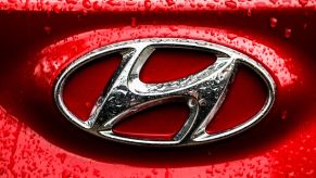 A chrome Hyundai logo on a red vehicle.