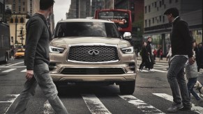 A gold 2021 Infiniti QX80 at a crosswalk.