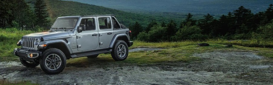 A gray 2021 Jeep Wrangler driving through the mountains.