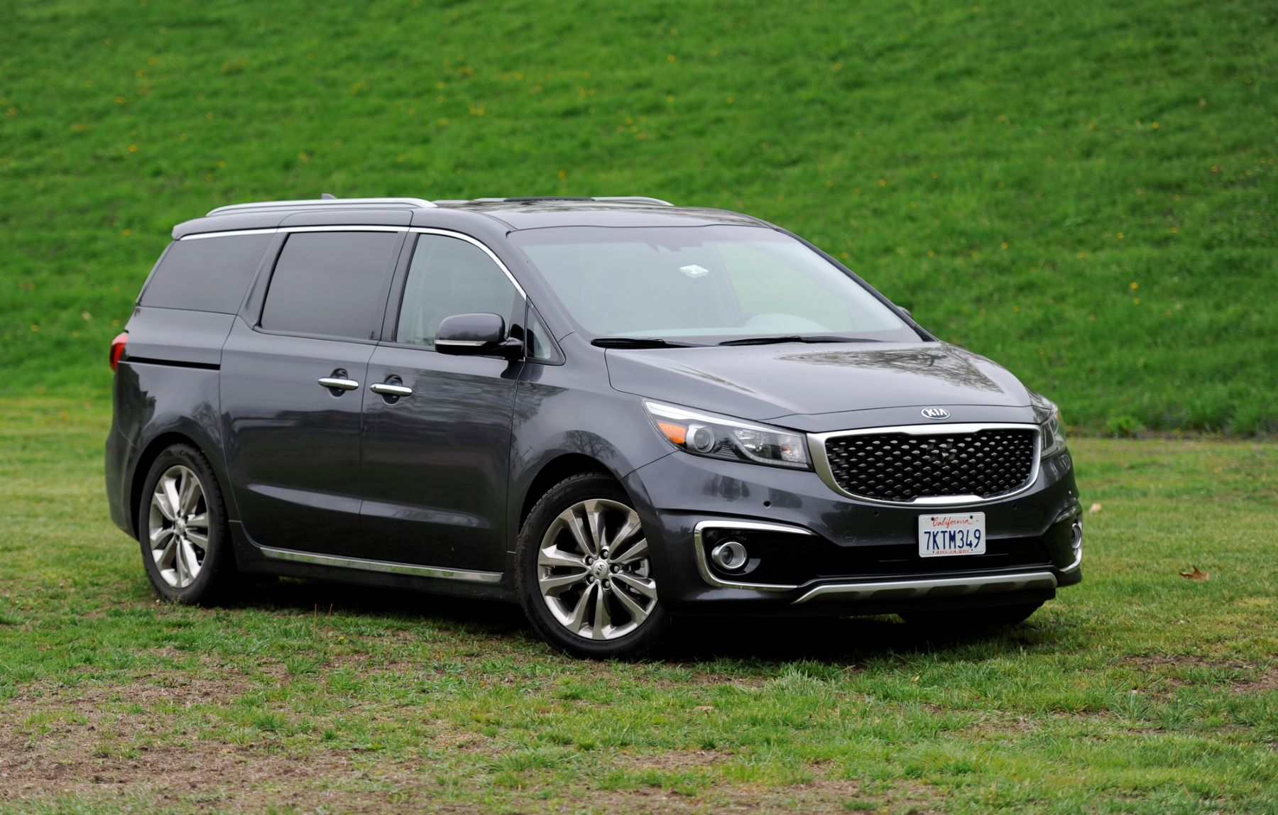 The 2016 Kia Sedona SXL minivan parked on a field of grass