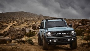 Light blue 2021 Ford Bronco driving on rocky terrain