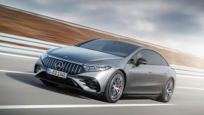 A metallic-gray Mercedes-AMG EQS 43 4Matic+ drives down a road