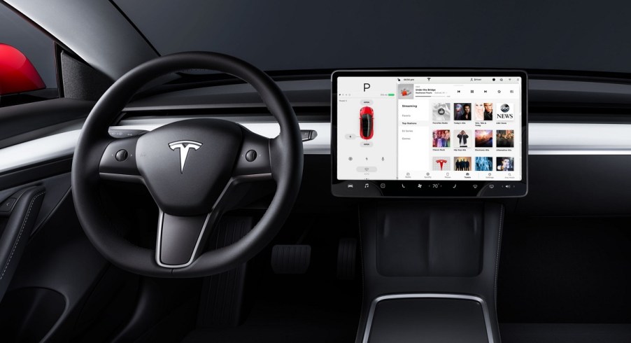 The steering wheel and screen of the inside of a Tesla Model 3.