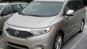 a gold 2011 nissan quest parked in a parking lot during the day