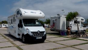 Two RVs parked on a concrete pad.