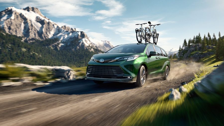 A green 2021 Toyota Sienna driving on a dirt road