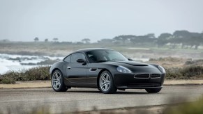 Smit Vehicle Engineering "Oletha" based on the BMW Z8. Shown here in black photographed on a patch of asphalt with a beach in the background.