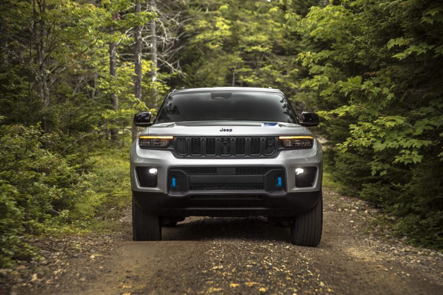 Silver 2022 Jeep Grand Cherokee 4xe driving through a forest