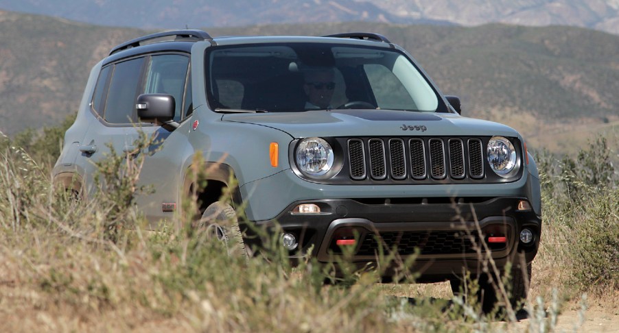 A green Jeep Renegade Trailhawk is on a trail.