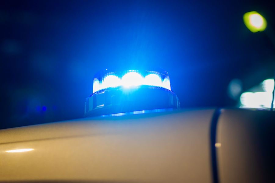 A blue light on top of a police car, potentially taking car of illegal activity.