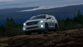 A 2022 Toyota Sequoia in green parked on a mountain top at night