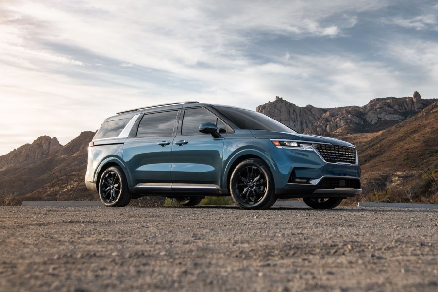 Turquoise 2022 Kia Carnival with mountains in the background