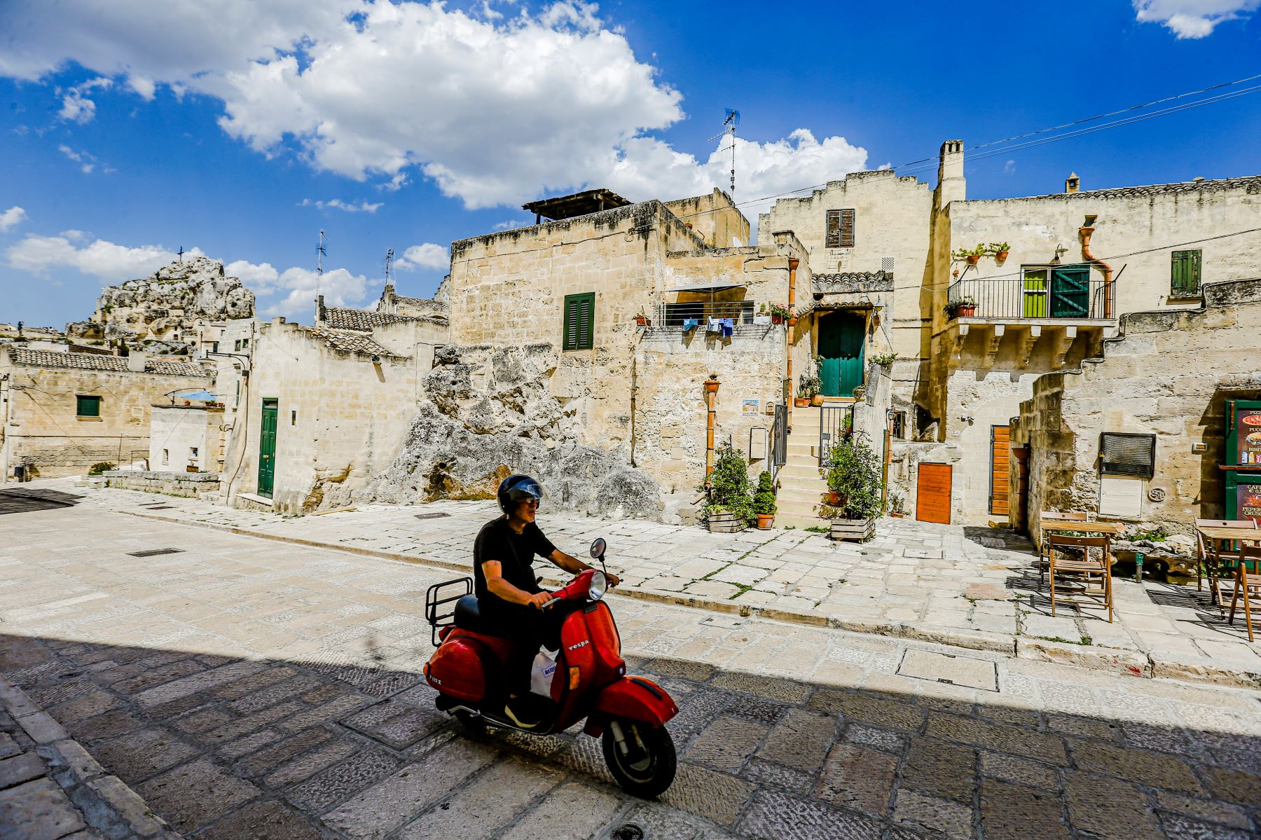 A man driving a Vespa scooter in Basilicata, Italy