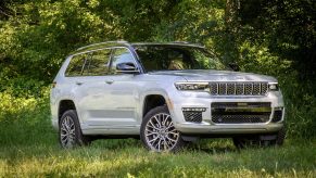 White 2021 Jeep Grand Cherokee L parked next to a forest