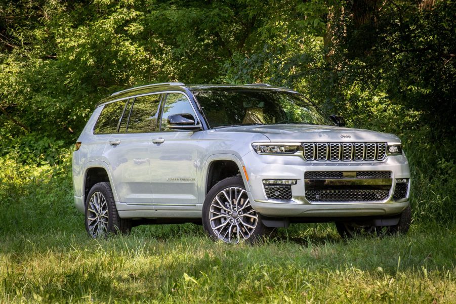 White 2021 Jeep Grand Cherokee L parked next to a forest