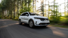 White 2022 Kia Sorento Plug-In Hybrid driving through a forest